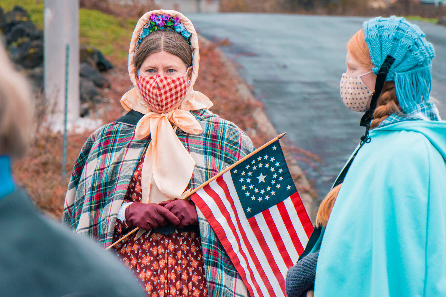 Re-enactor Nevi Meyers, right, looks on as Jennifer Hase holds onto a 1863 Flag during the Veterans Memorial Museum static parade for Veterans Day in November 2020.